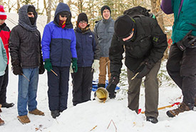 Scouts pouring hot maple syrup on snow to make maple taffy (Photo by Andrea Burbidge Photography)