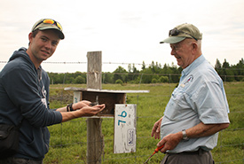Cameron Curran (left) and Herb Furniss (right) displaying an Eastern Bluebird chick and the interior of a nesting box (Photo by 2014 MudInspired.com)