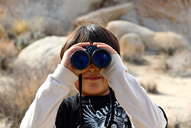 Enfant observant avec des jumelles (Domaine public)