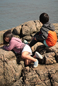 Heidi and Damien sitting by the rocks and taking in the ocean view. (Photo by Yves Cheung)