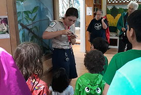 Presqu'ile Provincial Park Nature Centre's Isabella showing children how to tag a monarch butterfly (Photo by Kate Cranney) 