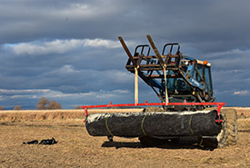 The team installs the tarps with the help of a tractor (Photo by NCC)