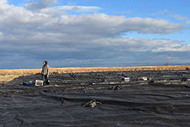 A team member examines a tarp (Photo by NCC)