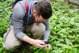 Inventorier la biodiversité sur les propriétés de CNC est un aspect important du suivi de la santé des écosystèmes. Ici, Mitchell MacMillan prend une photo d'une plante durant une évaluation sur l'île d'Holman, à l'Île-du-Prince-Édouard, pour l'identifier et enregister son observation. (Photo de Sean Landsman)